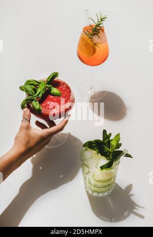 Gin-tonic, Aperol Spritz e basilico di fragola Margarita in mano womans Foto Stock