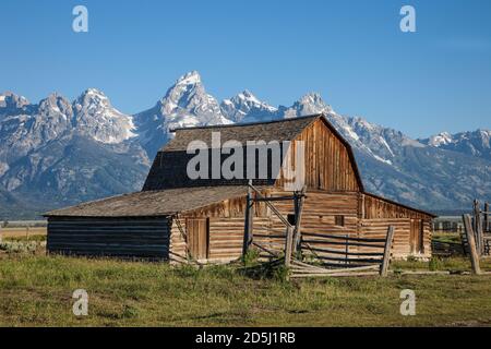 Il vecchio fienile di tronchi sulla casa di John Moulton su Mormon Row nel Grand Teton National Park con la catena di Teton dietro. Wyoming, Stati Uniti. Foto Stock