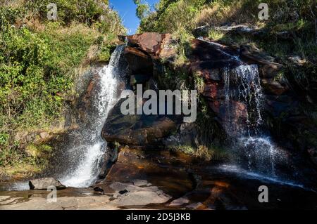Vista ravvicinata della cascata di Mato Limpo circondata da vegetazione verde e acque cristalline che spruzzano sulle formazioni rocciose. Cunha, San Paolo - Brasile. Foto Stock