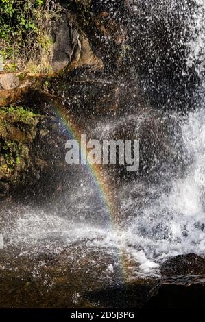 Vista ravvicinata della cascata di Mato Limpo, acque cristalline che si tuffano sulle formazioni rocciose e formano un arcobaleno nell'aria. Cunha, San Paolo - Brasile. Foto Stock