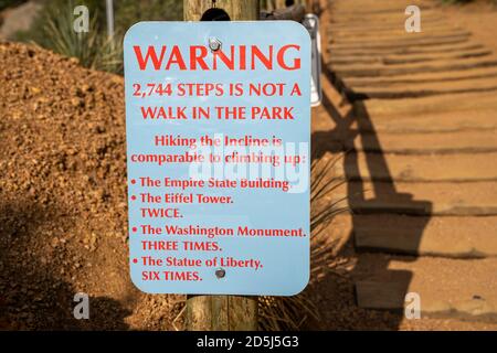 Un cartello di avvertimento alla base dell'escursione Manitou Incline in Colorado, ricorda agli escursionisti che si tratta di un'escursione difficile sulle scale Foto Stock