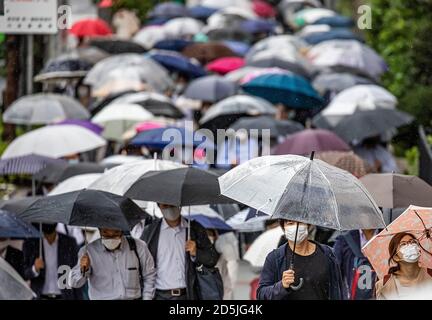 2020/10/09 - un mare di ombrelloni è formato da pendolari che si dirigeranno a lavorare su una mattinata iridata vicino alla stazione di Kachidoki. Kachidoki, Chuo City, Tokyo, Giappone. Credit: Ivo Gonzalez/AFLO/Alamy Live News Foto Stock