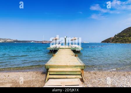 Molo sulla spiaggia con ombrelloni e lettini in Mediterraneo mare Foto Stock