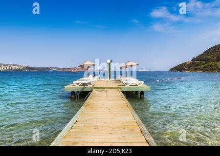 Molo sulla spiaggia con ombrelloni e lettini in Mediterraneo mare Foto Stock