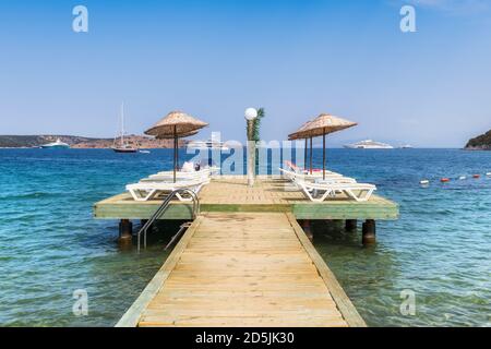 Molo sulla spiaggia con ombrelloni e lettini in Mediterraneo mare Foto Stock