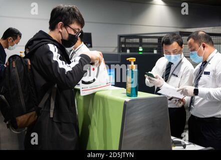 (201014) -- CHANGSHA, 14 ottobre 2020 (Xinhua) -- il personale controlla le informazioni di un passeggero del volo CZ6043 all'aeroporto internazionale Changsha Huanghua di Changsha, capitale della provincia di Hunan della Cina centrale, 13 ottobre 2020. La China Southern Airlines ha ripreso il suo volo Changsha-Nairobi mercoledì mattina, che è la prima rotta intercontinentale regolare ripresa dopo la pandemia COVID-19 nella provincia di Hunan della Cina centrale. (Xinhua/Chen Sihan) Foto Stock