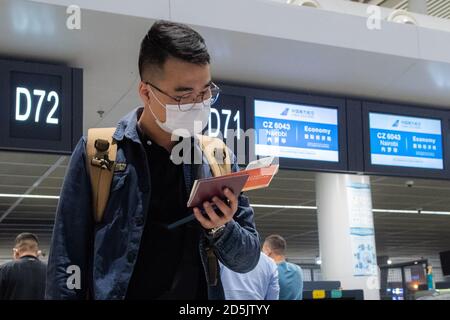 (201014) -- CHANGSHA, 14 ottobre 2020 (Xinhua) -- UN passeggero del volo CZ6043 controlla il biglietto all'aeroporto internazionale Changsha Huanghua di Changsha, capitale della provincia di Hunan della Cina centrale, 13 ottobre 2020. La China Southern Airlines ha ripreso il suo volo Changsha-Nairobi mercoledì mattina, che è la prima rotta intercontinentale regolare ripresa dopo la pandemia COVID-19 nella provincia di Hunan della Cina centrale. (Xinhua/Chen Sihan) Foto Stock