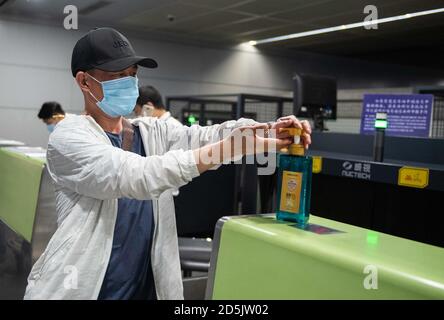 (201014) -- CHANGSHA, 14 ottobre 2020 (Xinhua) -- UN passeggero del volo CZ6043 sanitizza le mani all'aeroporto internazionale Changsha Huanghua di Changsha, capitale della provincia di Hunan della Cina centrale, 13 ottobre 2020. La China Southern Airlines ha ripreso il suo volo Changsha-Nairobi mercoledì mattina, che è la prima rotta intercontinentale regolare ripresa dopo la pandemia COVID-19 nella provincia di Hunan della Cina centrale. (Xinhua/Chen Sihan) Foto Stock