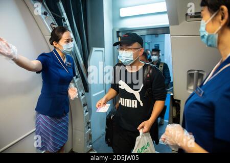 (201014) -- CHANGSHA, 14 ottobre 2020 (Xinhua) -- i passeggeri del volo CZ6043 saliscono a bordo dell'aereo all'aeroporto internazionale Changsha Huanghua di Changsha, capitale della provincia di Hunan della Cina centrale, 14 ottobre 2020. La China Southern Airlines ha ripreso il suo volo Changsha-Nairobi mercoledì mattina, che è la prima rotta intercontinentale regolare ripresa dopo la pandemia COVID-19 nella provincia di Hunan della Cina centrale. (Xinhua/Chen Sihan) Foto Stock