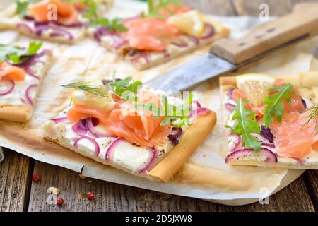 Tarte Flambee dall'Alsazia con salmone affumicato e foglie di razzo Foto Stock