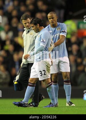 Carlos Tevez (centro) di Manchester City lascia il campo di gioco dopo aver raccolto una ferita al suo hamping Foto Stock