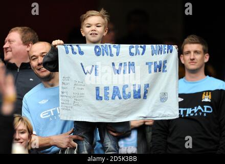 Un giovane fan di Manchester City ha un banner in mano Le bancarelle che recita "piangerò solo quando vinceremo il campionato' Foto Stock