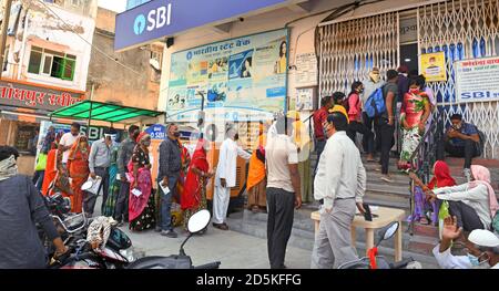 Beawar, Rajasthan, India, 13 ottobre 2020: I clienti si levano in piedi in una lunga coda fuori di una filiale della banca per prelevare i soldi per la prossima stagione di festa in mezzo alla pandemia di Coronavirus, a Beawar. Credit: Sumit Saraswat/Alamy Live News Foto Stock