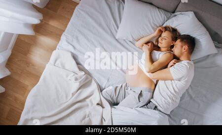 Felice giovane coppia dormendo insieme nel letto, Sweet Loving giovani persone che si tiene a vicenda mentre dormono. Bella Donna è incinta, amorevole Foto Stock