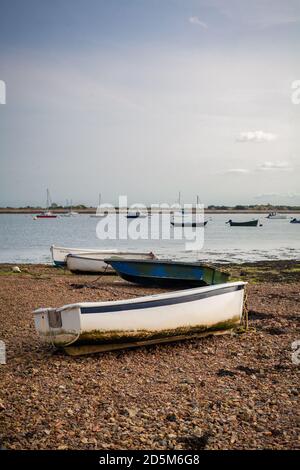 Tre gommoni ormeggiati a bassa marea sulla costa meridionale dell'Inghilterra sotto il sole. Foto Stock