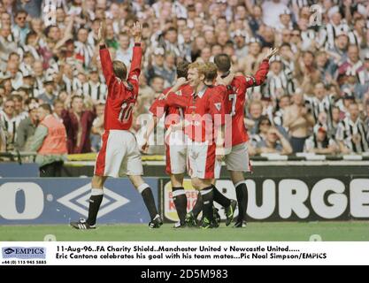 11 agosto 96. Fa Charity Shield. Manchester United contro Newcastle United. Eric Cantona celebra il suo obiettivo con i suoi compagni di squadra Foto Stock