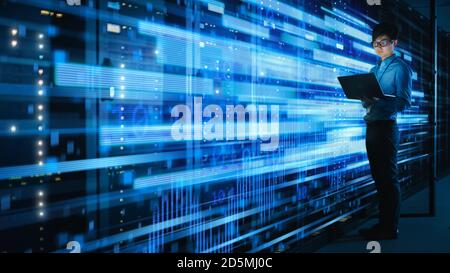 Foto di specialisti IT asiatici che utilizzano notebook in data center con server rack completi. Concetto di connessioni Internet ad alta velocità con visualizzazione blu Foto Stock