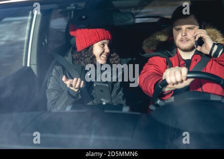 coppia in auto in inverno vestito guida e parlare Foto Stock