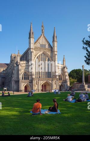 Winchester Cathedral, vista in estate di persone che si rilassano nei terreni della Winchester Cathedral, Hampshire, Inghilterra, Regno Unito Foto Stock