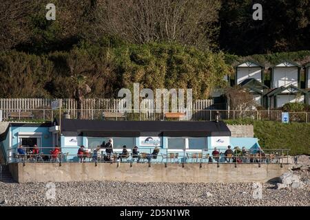 Langland Bay, Swansea, Regno Unito. 14 ottobre 2020. La gente siede fuori dal Surfside Cafe nel glorioso clima d'autunno a Langland Bay vicino a Swansea questa mattina. Come altre parti del Galles e del Regno Unito, Swansea è attualmente in stato di blocco (dal 27 settembre 2020) a seguito di un forte aumento dei casi di coronavirus (COVID-19) nella zona del comune e della contea di Swansea Council. Credit: Phil Rees/Alamy Live News Foto Stock