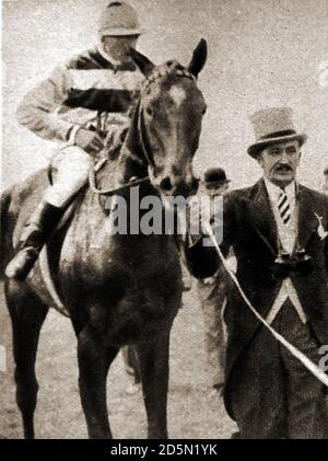 1932 Tom Walls, l'allora popolare attore, proprietario di cavalli e allenatore, guidando il suo cavallo il quinto aprile dopo aver vinto l'inglese Derby. Thomas Kirby Walls (1949 – 1883) è stato un . Conosciuto soprattutto per aver presentato e co-starring nelle farse di Aldwych negli anni '20 e per aver interpretato e diretto i loro adattamenti cinematografici. Ha allestito scuderie a casa sua in Surrey e ha formato con successo circa 150 vincitori, tra cui il quinto aprile, il suo vincitore del Derby nel 1932. Il 5 aprile è stato un cavallo da corsa e un siré britannico. Jockey è Fred (Frederick) Lane. Foto Stock