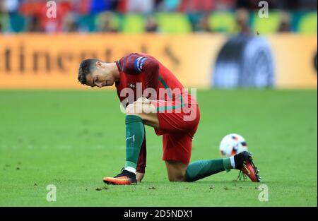 Il portoghese Cristiano Ronaldo siede sul terreno ferito nelle prime fasi del gioco. Foto Stock