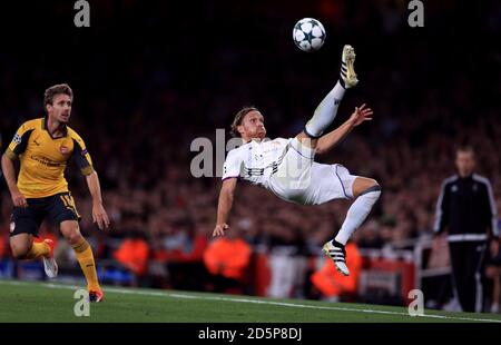 Michael Lang del FC Basel schiarisce la palla acrobaticamente guardata da Nacho Monreal dell'Arsenal Foto Stock