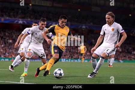 Alexis Sanchez dell'Arsenal contro Michael Lang e. FC Basel's Taulant Xhaka (a sinistra) Foto Stock