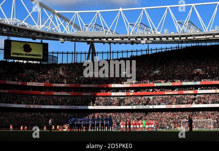 I giocatori di Arsenal e Tottenham Hotspur stanno in braccio prima del gioco ricordare i militari e le donne che hanno perso il loro vive combattendo per il loro paese Foto Stock