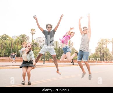 Un gruppo di amici che sono felici e saltano in città. Foto Stock