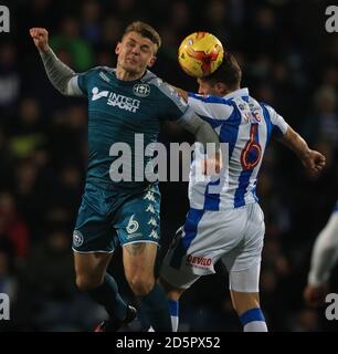 Jonathan Hogg di Huddersfield Town (a destra) e il potere massimo di Wigan Athletic (a sinistra) combatti per la palla in aria Foto Stock