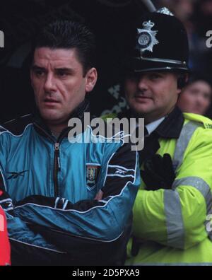 John Gregory, manager di Aston Villa, con un poliziotto davanti al gioco Foto Stock