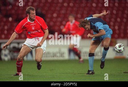 Il Jon Olav Hjelde di Nottingham Forest (a sinistra) guarda a Cambridge United's Martin Butler (a destra) cerca di controllare la palla Foto Stock