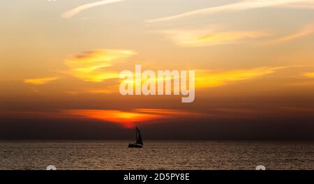 Barca a vela lungo un vivace tramonto colorato. Golfo di Finlandia. Foto Stock