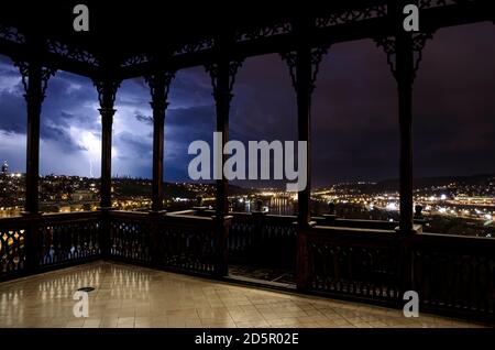 Vista della città illuminata durante la tempesta con il fulmine dalla galleria in legno aperto o gazebo a Praga, Repubblica Ceca. Foto Stock