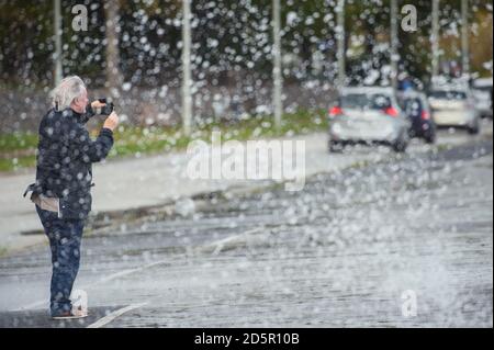 Kiel, Germania. 14 ottobre 2020. Un uomo usa il suo smartphone per filmare il riggere e spruzzare nel fiordo di Kiel. La tempesta orientale ha causato anche inondazioni a Kiel. Credit: Gregor Fischer/dpa/Alamy Live News Foto Stock