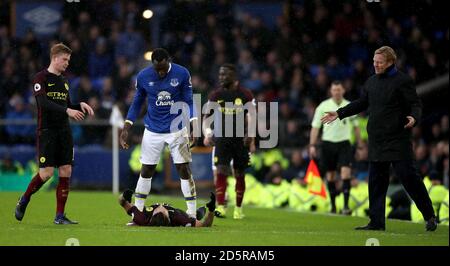 Romelu Lukaku di Everton (centro) e Nicolas Otamendi di Manchester City (in basso) Scontro con il manager di Everton Ronald Koeman (a destra) e Manchester City's. Kevin De Bruyne (a sinistra) guarda sopra Foto Stock