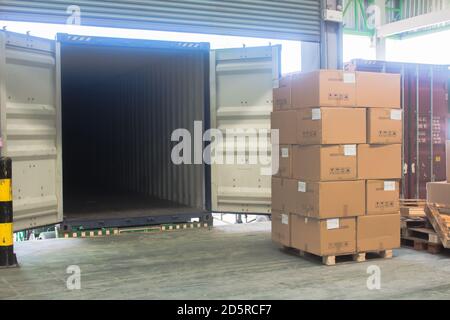 carico spedizione scatole di cartone e merci su pallet di legno a. caricamento del dock dal contenitore Foto Stock