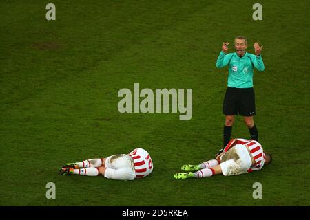 L'arbitro Martin Atkinson chiama per il fisico come Charlie Adam di Stoke City, (a sinistra) e Marko Arnautovic di Stoke City sono feriti Foto Stock