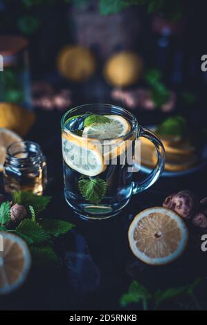 Tè caldo con limone e menta in una tazza di vetro Foto Stock