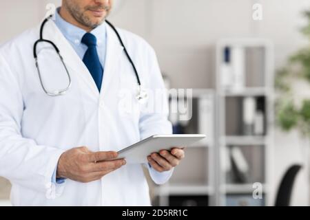 Primo piano del medico che usa il tablet digitale in clinica Foto Stock