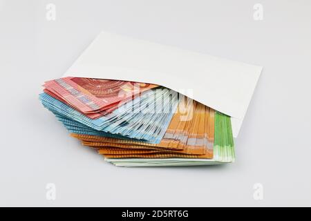 banconote da 100, 50, 20 e 10 euro in busta bianca. Sfondo separato. Tangente Foto Stock