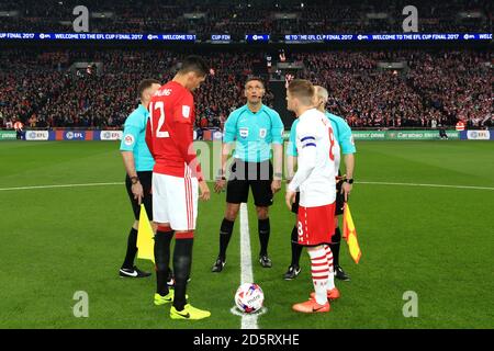 Chris Smalling di Manchester United (a sinistra) e Steven Davis and di Southampton Arbitro Andre Marriner durante il lancio della moneta Foto Stock