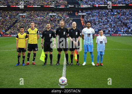 I capitani di Coventry City e Oxford United si allineano con la partita funzionari e mascotte prima del calcio d'inizio Foto Stock