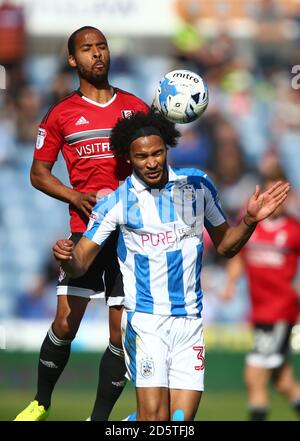 Dennis Odoi di Fulham (a sinistra) e la battaglia di Isaiah Brown di Huddersfield Town per la sfera Foto Stock