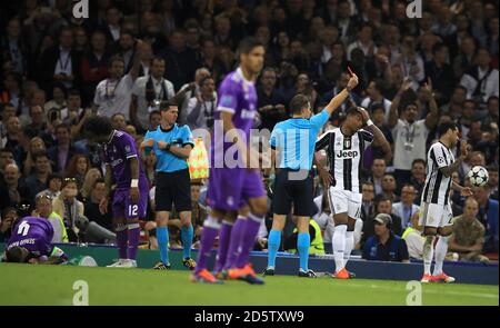 L'arbitro Felix Brych mostra una carta rossa a Juan Cuadrado di Juventus (non raffigurato) dopo una sfida su Sergio Ramos del Real Madrid (a sinistra) durante la finale della Champions League 2017 che si tiene allo Stadio Nazionale di Cardiff Foto Stock