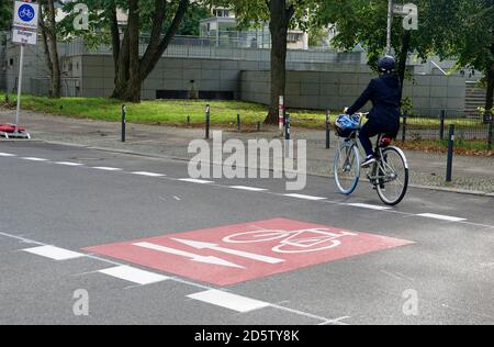 06 ottobre 2020, Berlino: Un ciclista passa sopra un pittogramma in bicicletta sulla Weidenweg nel quartiere berlinese di Friedrichshain. La pista ciclabile pop-up è stata allestita dal distretto in estate. La nuova pista ciclabile si snoda per tre chilometri da Palisadenstraße via Weidenweg fino a Rigaer Straße e collega Lichtenberger Straße a ovest con la stazione Frankfurter Allee S-Bahn a est. Foto: Alexandra Schuler/dpa Foto Stock