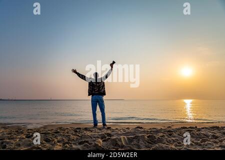 Due adulti saltano la silhouette di fronte al mare - Dammam Arabia Saudita. Foto Stock