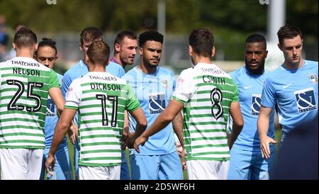 Jordan Willis (centro) di Coventry City e i suoi compagni di squadra si stringono le mani Con i giocatori di Yeovil Town prima del gioco Foto Stock