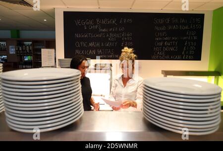 Il personale si trova di fronte a un cartello che advertisce sul cibo vegetariano all'interno dell'ospitalità del New Lawn Stadium, sede della Forest Green Rovers Foto Stock